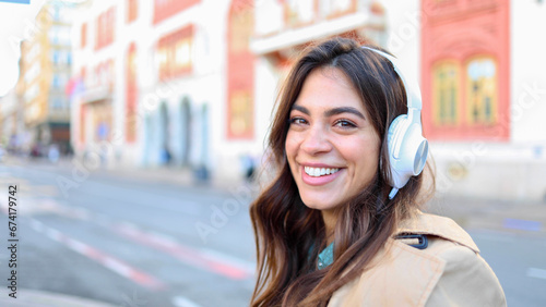 Young woman is listening to music and enjoying the outdoors