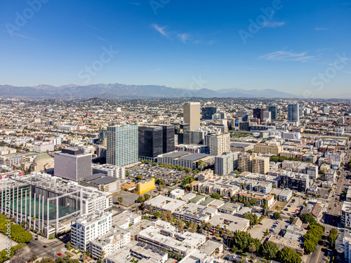 Los Angeles, California – October 30, 2023: aerial drone view toward Wilshire Blvd at LA Koreatown with bank buildings, apartments, houses, and LA Downtown at sunny day  photo