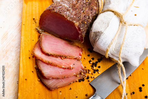 Sliced Polish cured sirloin pork polendvitsa on wooden cuting board. Traditional meat delicacies.. photo