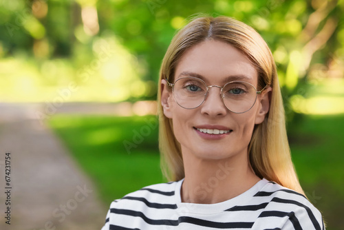Portrait of confident female entrepreneur outdoors. Beautiful woman with glasses in park. Space for text