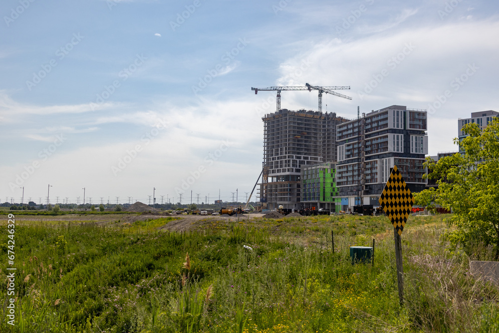 Construction site - cranes - buildings - greenery - blue sky