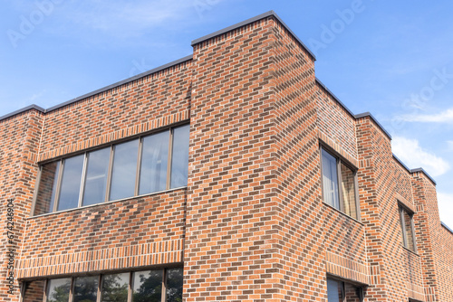 Brick building with windows - blue sky with clouds - architecture