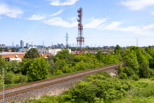 Railroad tracks - greenery - industrial area - tower - blue sky