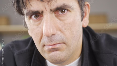 Man looking angry at camera. Big eyes.