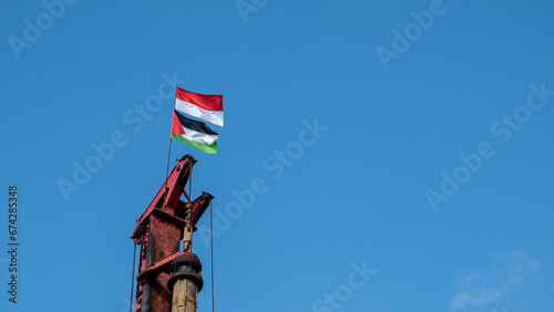 the Indonesian flag and the flag of the state of Palestine are flying on a pole