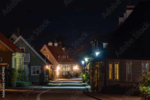 Fototapeta Naklejka Na Ścianę i Meble -  Bastad, Sweden Small cottages  at night on the landmark and picturesque Agardhsgatan and street lamps. .