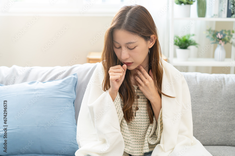 Sick, coronavirus or covid-19, illness asian young woman, girl with blanket have a fever, flu or sore throat and sneezing until chest pain while sitting on sofa at home. Health care on virus person. Sick, coronavirus or covid-19, illness asian young woman, girl with blanket have a fever, flu or sore throat and sneezing until chest pain while sitting on sofa at home. Health care on virus person.