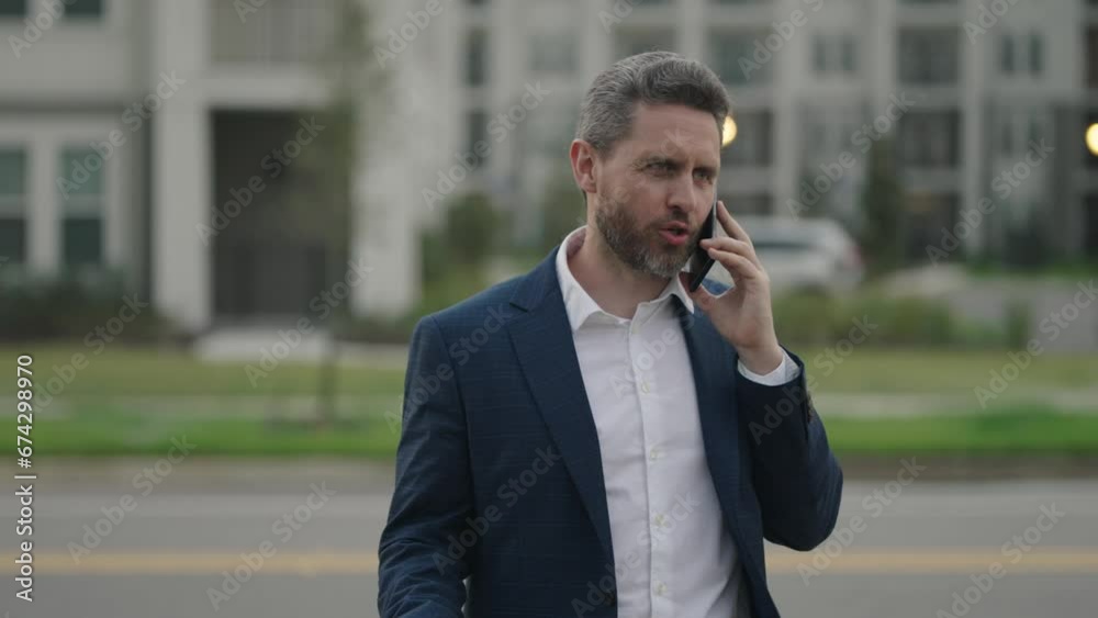 Portrait of a confident business man walking on street and speaking phone. Mature business man talking on phone outdoor. Businessman in a formal suit using phone. Portrait of a confident business man walking on street and speaking phone. Mature business man talking on phone outdoor. Businessman in a formal suit using phone.