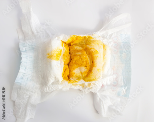 Baby Health Concept: Dirty stinky diaper with yellow poop of newborn baby photo