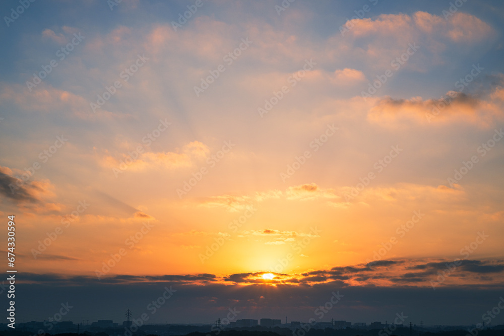 日の出の太陽と朝焼けの高積雲