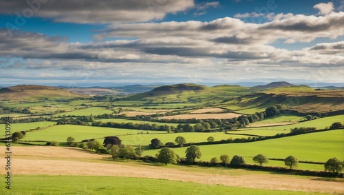 A panoramic countryside landscape with a green field and blue sky 