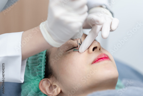 Woman receiving pico laser facial treatment under eye in beauty Clinic.