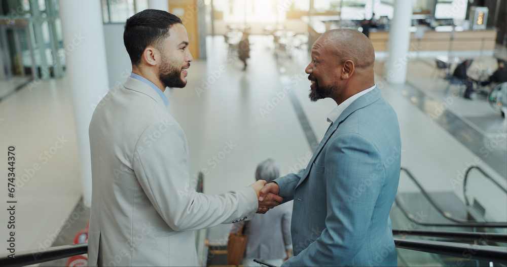 Obraz premium Happy businessman, handshake and meeting on escalator for partnership, b2b or deal at airport. Business people shaking hands with smile for travel, teamwork or agreement together on moving staircase