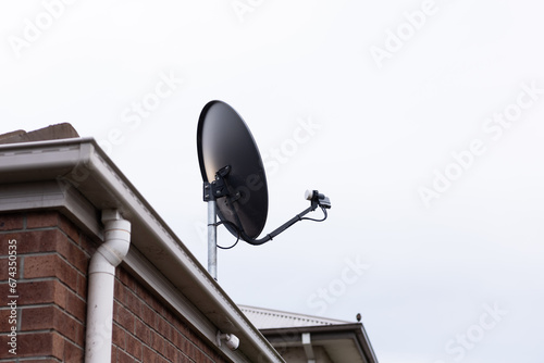 Satellite TV dish antenna on house roof photo