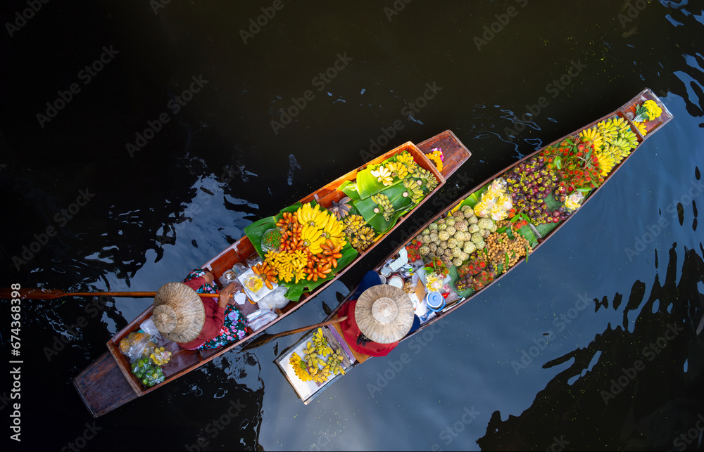 Fototapeta premium Famous Damnoen Saduak floating market in Thailand, Farmer goes to sell organic products, fruits, vegetables and Thai food, Ratchaburi province tourism concept. Thailand