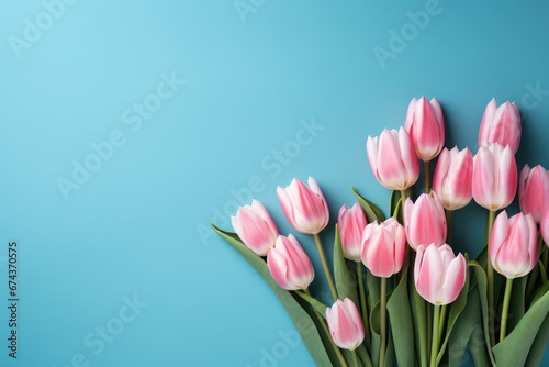 Beautiful bouquet of pink tulips stands out against vibrant blue background. This image is perfect for adding pop of color and elegance to any project or design.