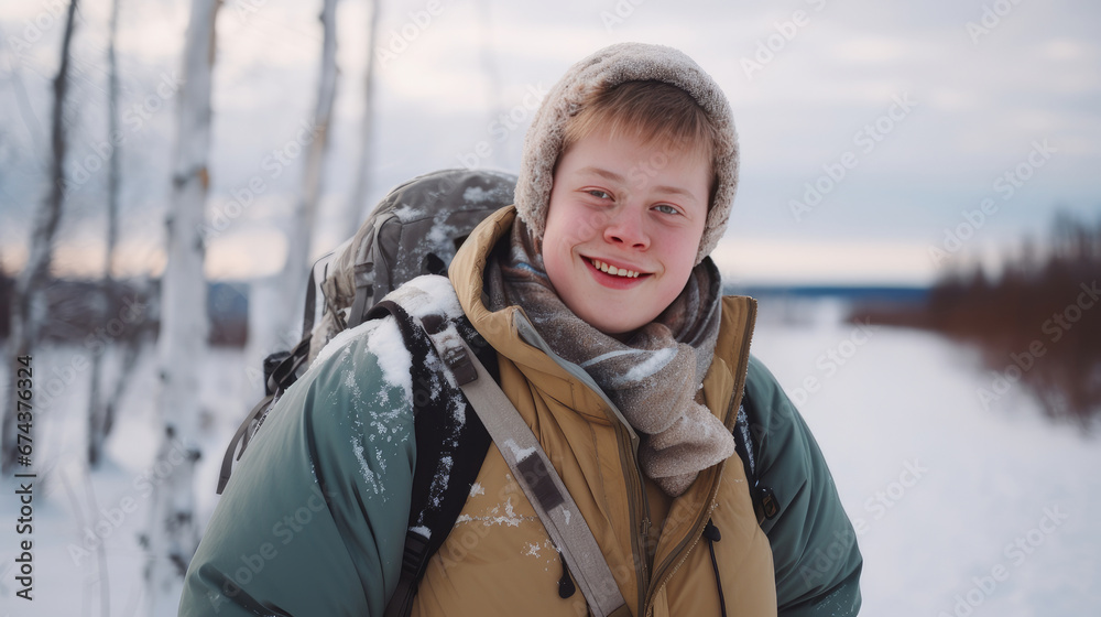 Portrait of a young, handsome, smiling and happy guy with Down syndrome against the backdrop of a winter snowy landscape. Portrait of a young, handsome, smiling and happy guy with Down syndrome against the backdrop of a winter snowy landscape.