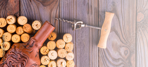 Bottle of wine with corks on wooden table background. on soft sunlight