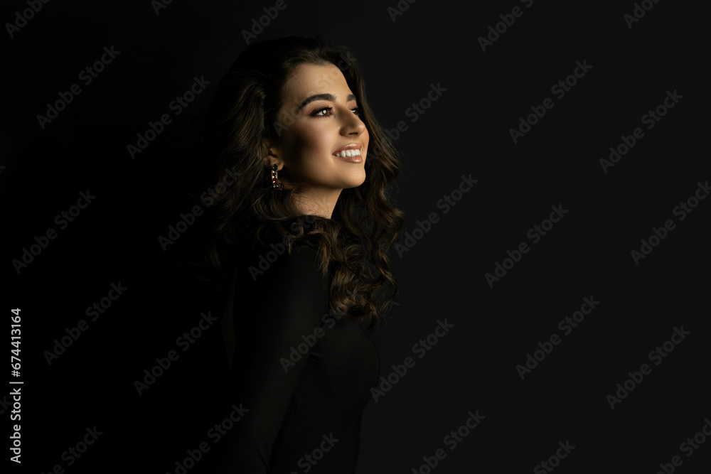 Portrait of an attractive female model in black, solated on a black background.