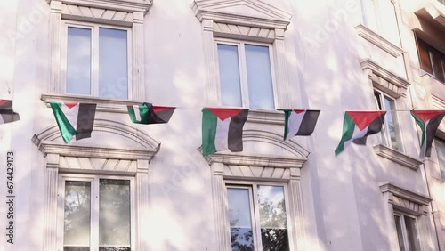 Guarland with Palestine flags waving in wind on a street in front of a house