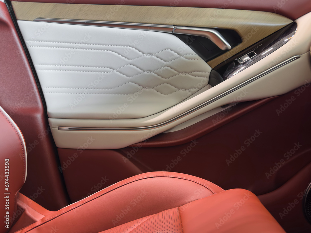 Modern luxury car brown leather interior. Part of orange leather car seat details with white stitching. Interior of prestige car. Comfortable perforated leather seats. Perforated leather.