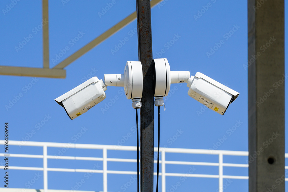 Pole with two outdoor security CCTV cameras or surveillance system in an unfinished construction site Pole with two outdoor security CCTV cameras or surveillance system in an unfinished construction site