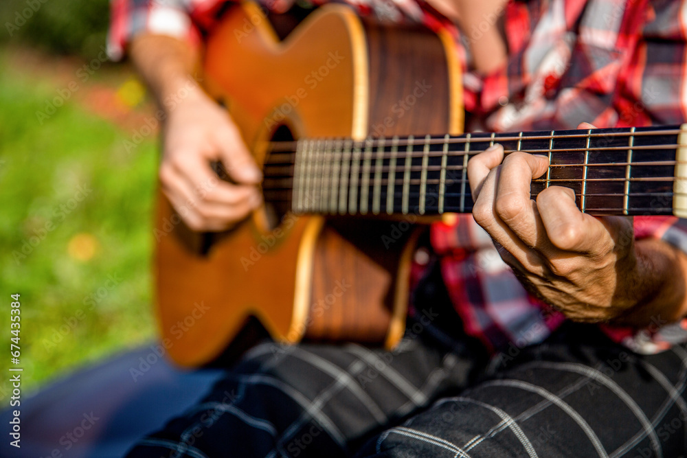 Fototapeta premium Acoustic guitars playing. Music concept. Guitars acoustic. Male musician playing guitar, music instrument. Man's hands playing acoustic guitar, close up