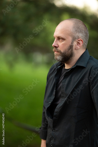 A handsome man in a black shirt in nature