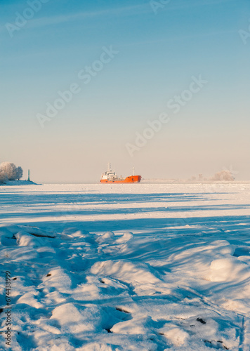 Winter shipping. Big cargo ship in frozen ice sea