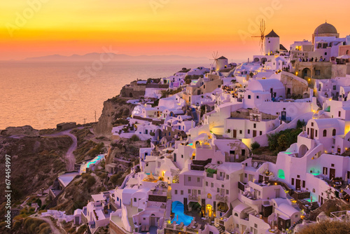 Oia Santorini Greece, sunset with white churches and blue domes by the ocean of Oia Santorini Greece, a traditional Greek village in Santorini.