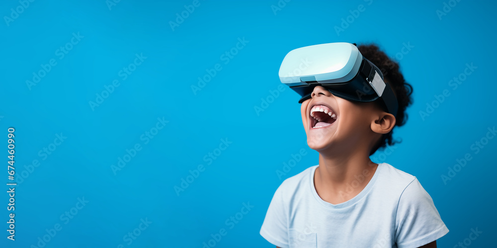 Young boy getting experience using VR headset glasses isolated on a blue background with copy space Young boy getting experience using VR headset glasses isolated on a blue background with copy space