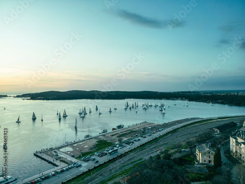 Aerial view of sailboats racing at Pula Regatta along the harbour at sunset, Pula, Istria, Croatia. photo