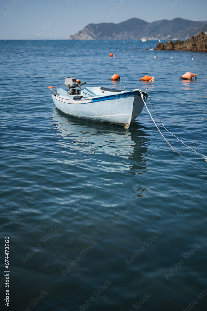 A small wooden boat with a motor in a quiet sea harbor - private transport for fishermen