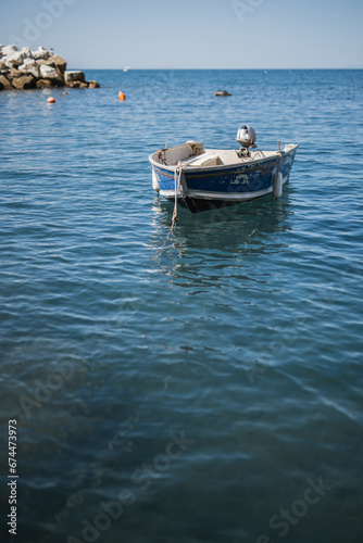A small wooden boat with a motor in a quiet sea harbor - private transport for fishermen © andrey gonchar