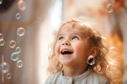 Happy blonde little girl excited looking up in the bubbles
