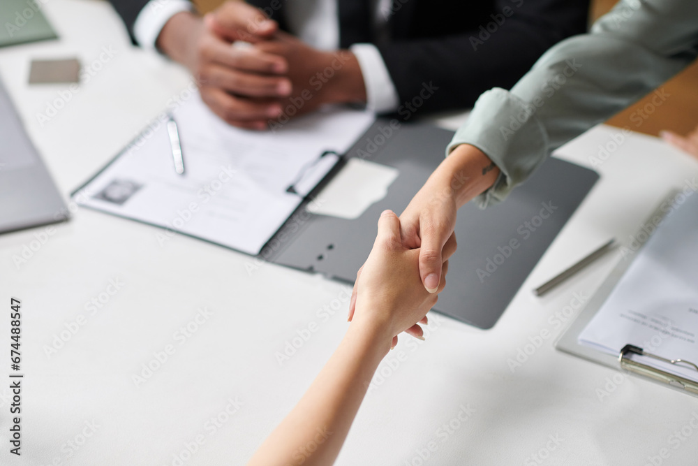 Company managers greeting new employee, shaking her hand