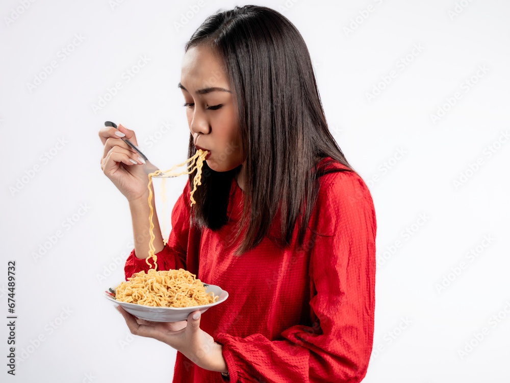 A portrait of a happy Asian woman wearing a red shirt, eating noodles. Isolated against a white background. A portrait of a happy Asian woman wearing a red shirt, eating noodles. Isolated against a white background.