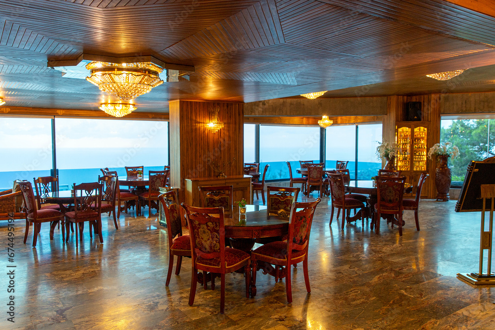 Fototapeta premium Interior of cozy restaurant with panoramic windows. Tables for four guests