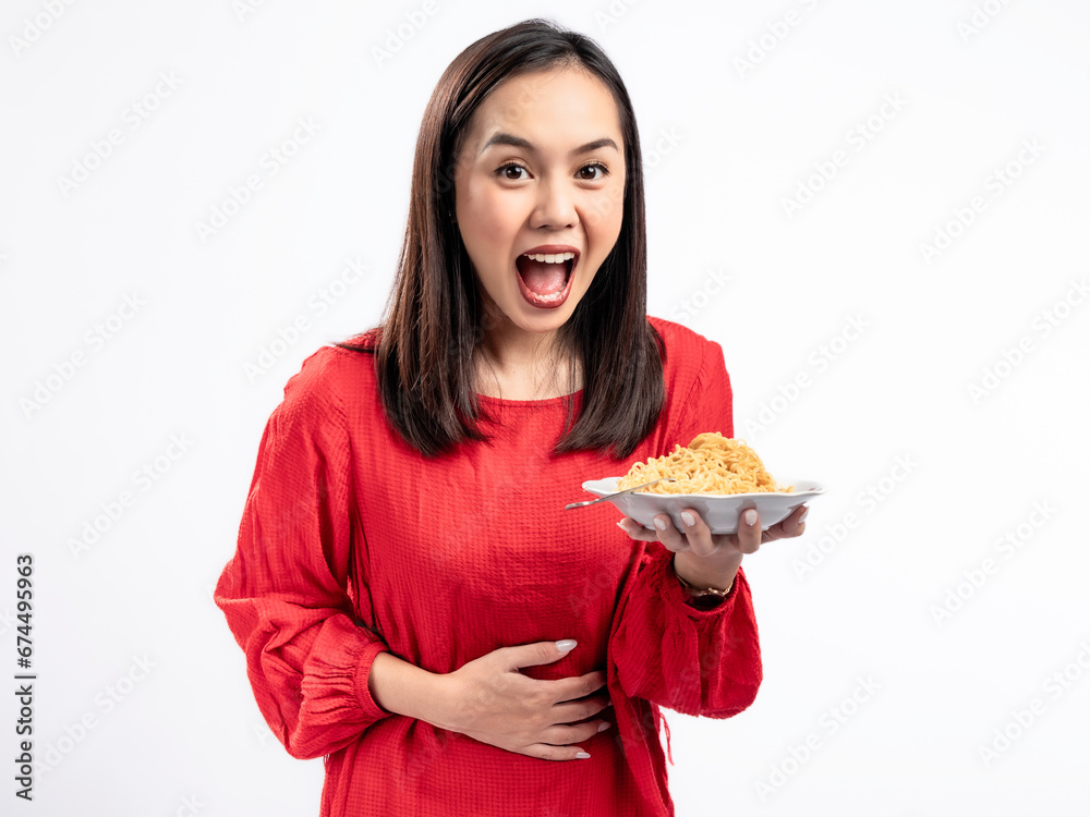 A portrait of a happy Asian woman wearing a red shirt, presenting noodles, and about to eat them. Isolated against a white background. A portrait of a happy Asian woman wearing a red shirt, presenting noodles, and about to eat them. Isolated against a white background.