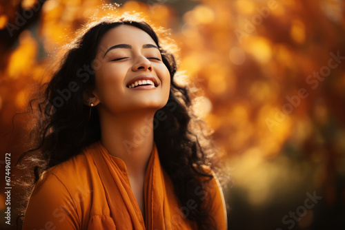 A Indian woman breathes calmly looking up enjoying autumn air