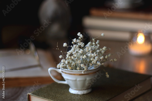Obraz na płótnie Vintage books, reading glasses, gold pen, hand model, gold jewelry, scented candles, flowers, chess pieces and cup of tea or coffee on the table