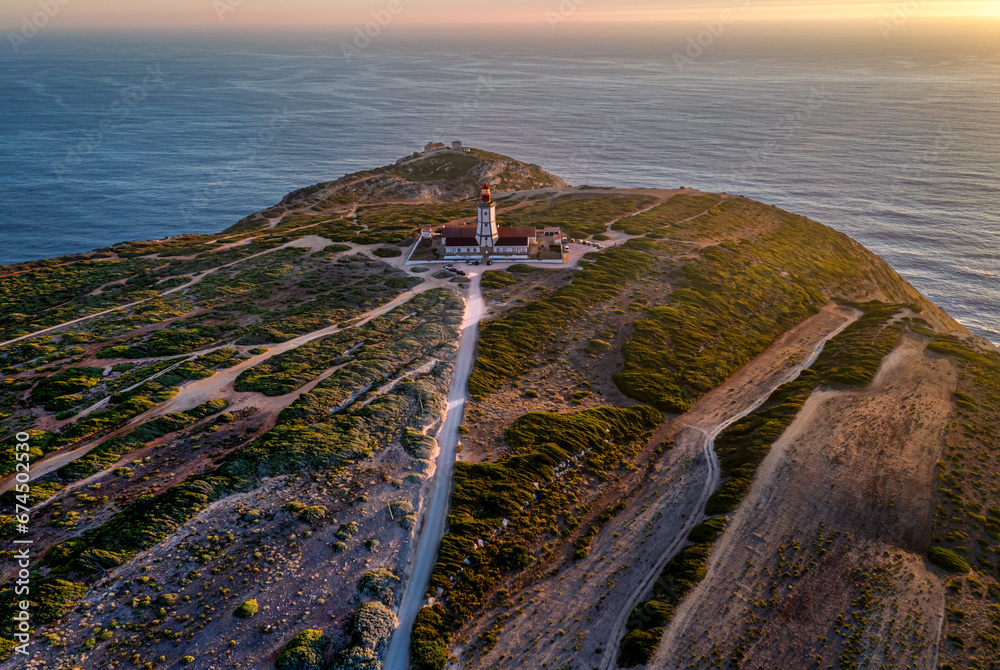 Sunset view of lighthouse, cliffs and sea horizon, cape Espichel