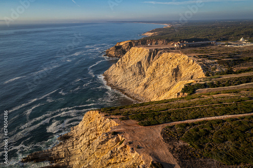 Obraz na płótnie High cliffs of cape Espichel, Portugal and ocean tide at sunset w salonie
