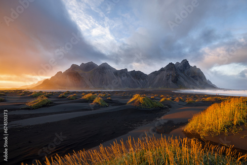 View over black beach in beautiful light with mount verstrahorn in background and dramatic sunset, Stokksnes, Höfn, Iceland  photo
