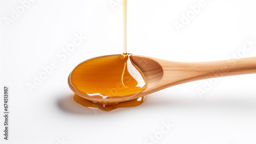 Honey dripping on a wooden spoon isolated on white background