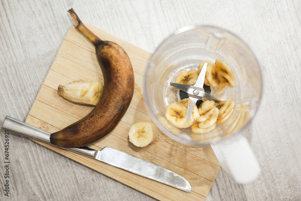 Banana shake in blender. Banana slices inside kitchen blender. Banana