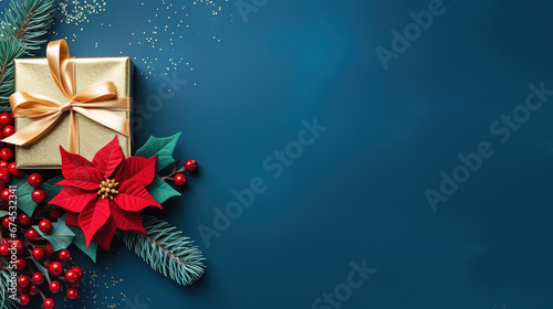 blue christmas background with poinsettia with leaves  red berries  gift box wrapped red silk ribbon  gold tinsel  with empty copy Space