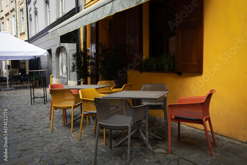 Yellow wall, chairs and tables in outdoor cafe