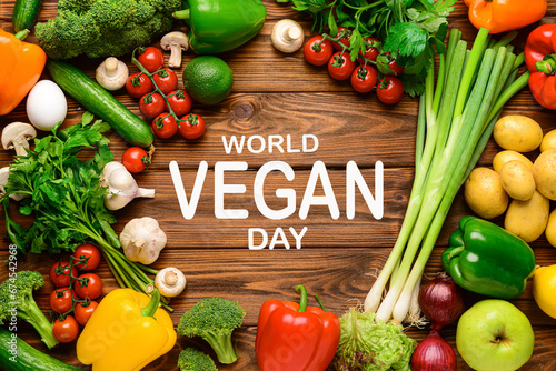 Different vegetables and text WORLD VEGAN DAY on wooden background