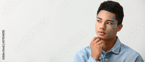 Creative portrait of handsome African-American guy on light background with s...